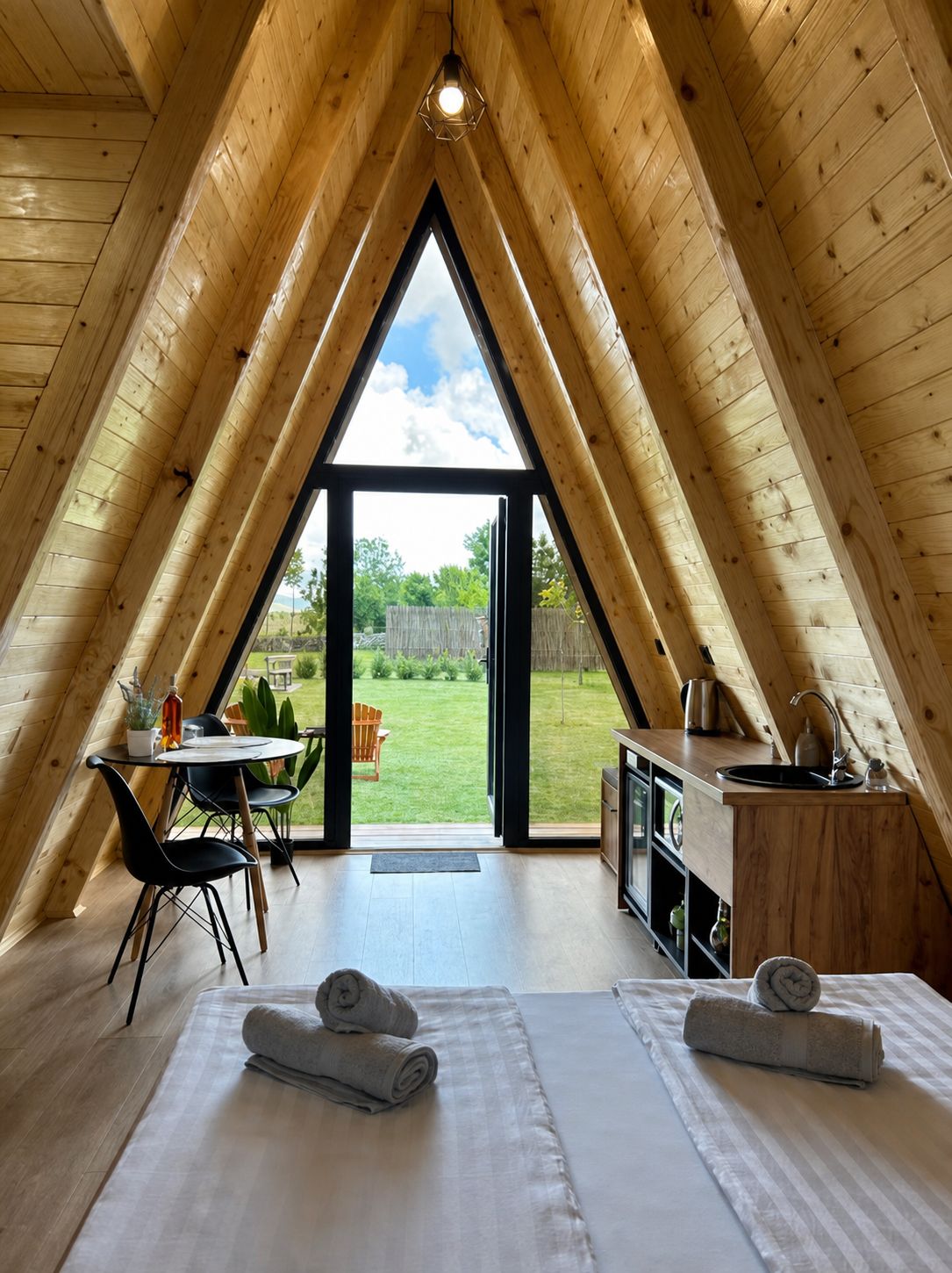View from the bed through the A-frame windows to the garden