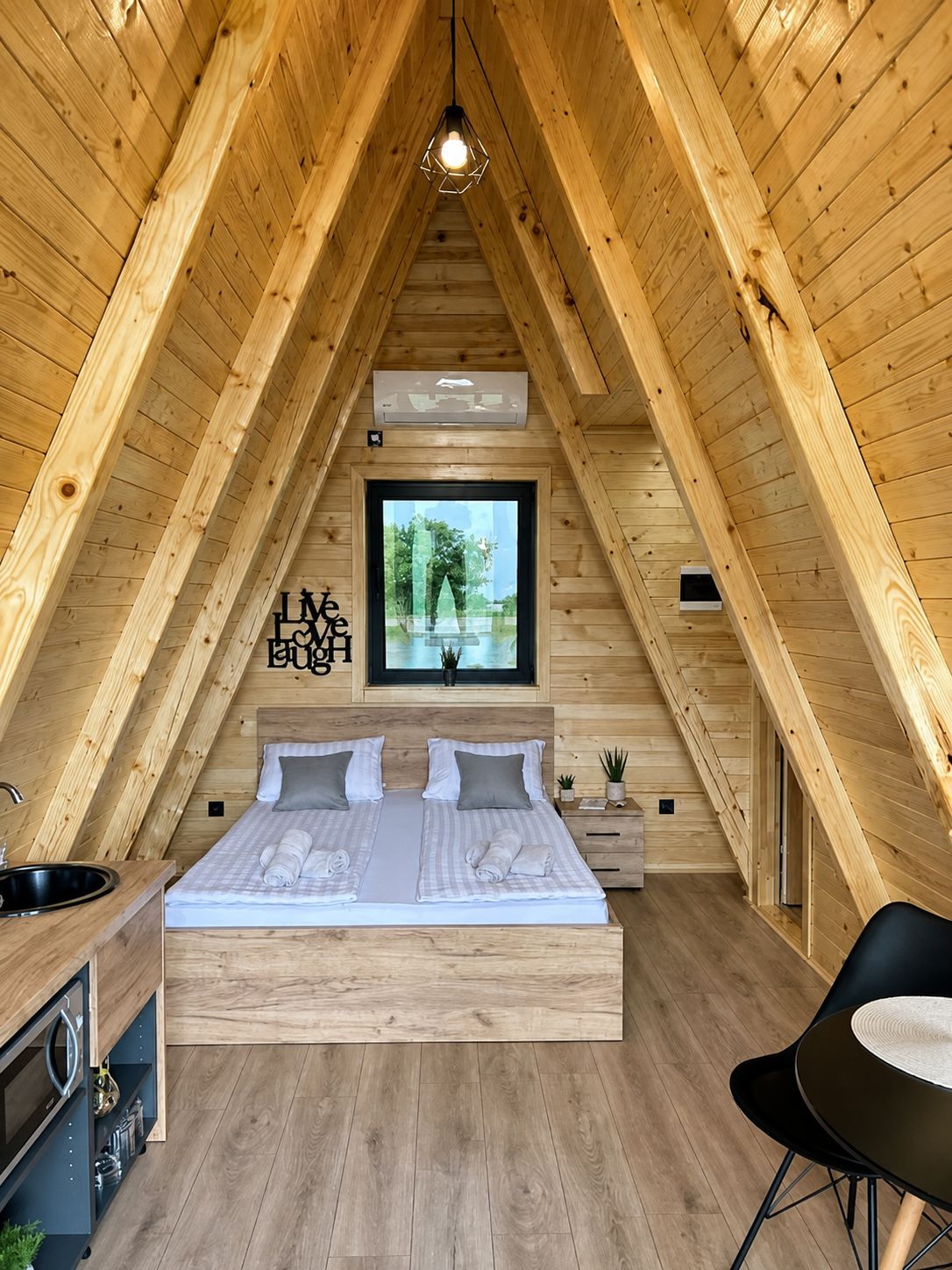 Full chalet interior with double bed, kitchenette and dining table